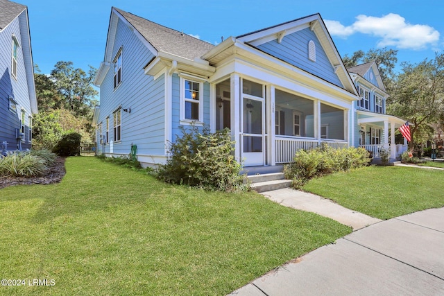 view of front facade with a sunroom and a front yard