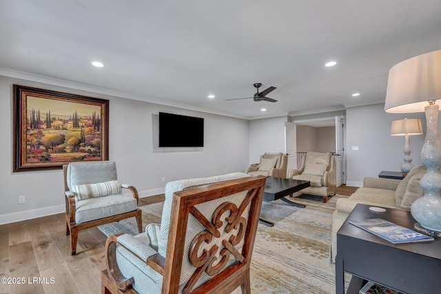 living room featuring crown molding, ceiling fan, and light hardwood / wood-style flooring