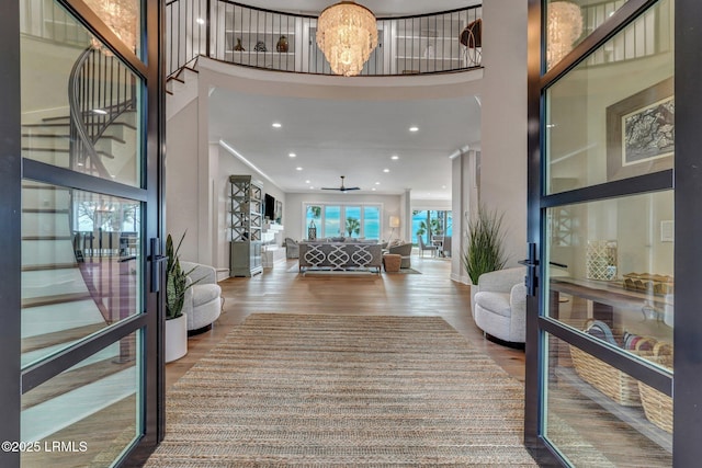 entryway featuring french doors, wood-type flooring, a chandelier, and a high ceiling