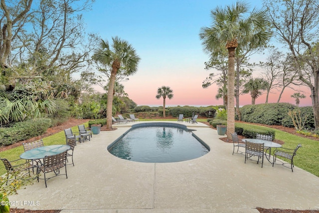 pool at dusk with a patio