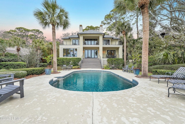 pool at dusk with a patio area