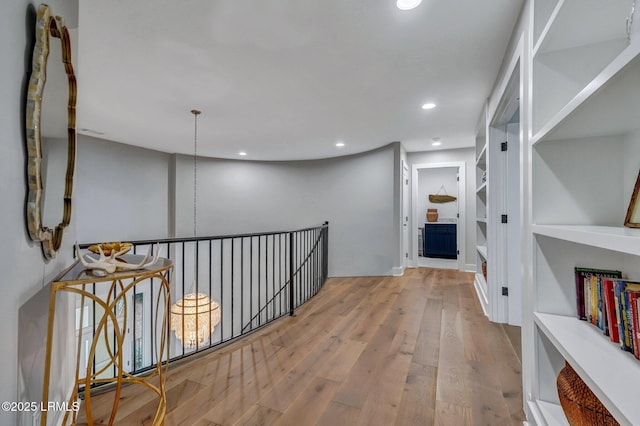 hallway with built in features and light wood-type flooring