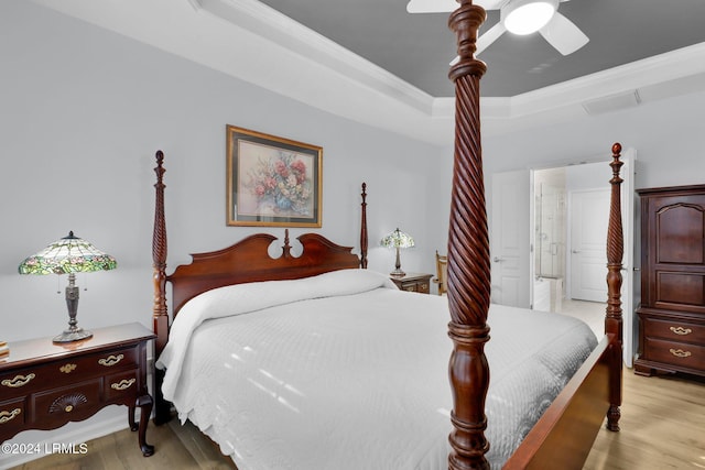 bedroom featuring crown molding, a raised ceiling, ceiling fan, and light wood-type flooring