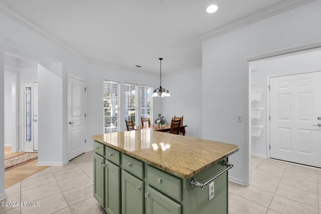 kitchen featuring crown molding, a center island, green cabinets, and light tile patterned floors