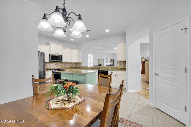 dining room with crown molding, a notable chandelier, and light tile patterned floors