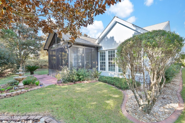 view of front of house with a front yard and a sunroom