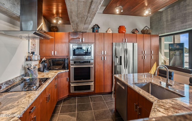 kitchen with appliances with stainless steel finishes, island range hood, light stone countertops, and sink