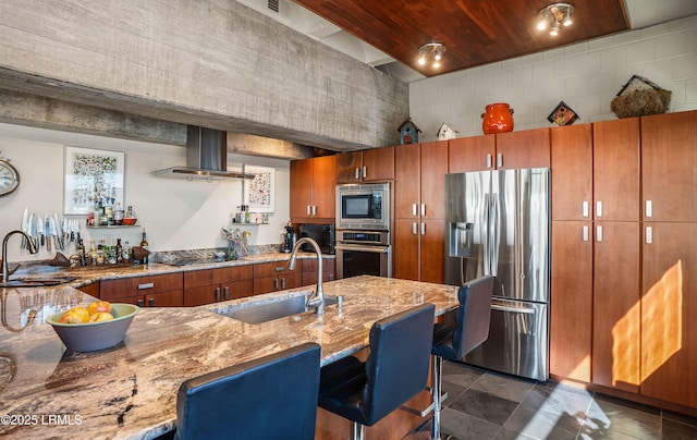 kitchen featuring appliances with stainless steel finishes, sink, a breakfast bar area, and exhaust hood