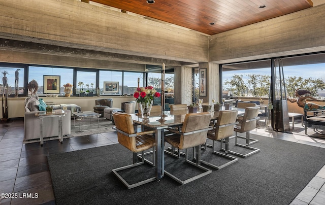 tiled dining room with a towering ceiling, a wealth of natural light, and wooden ceiling