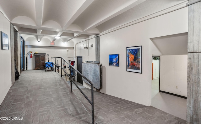 hall with coffered ceiling, beam ceiling, and carpet