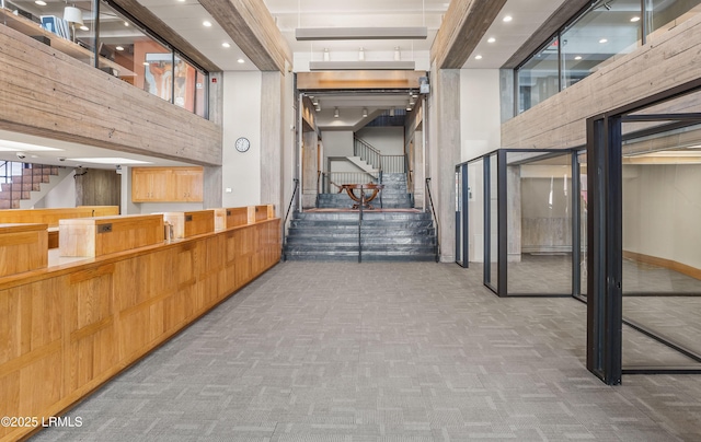 hallway featuring a high ceiling and carpet flooring