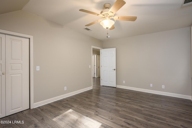 unfurnished bedroom with lofted ceiling, dark wood-type flooring, a closet, and ceiling fan