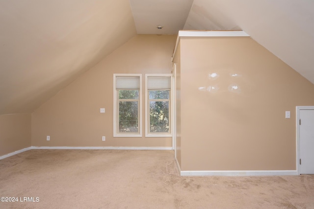 bonus room featuring vaulted ceiling and light colored carpet