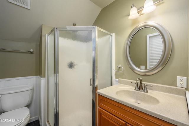 bathroom featuring vanity, a shower with door, and toilet