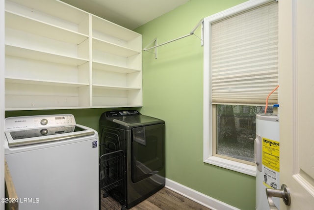 laundry room featuring electric water heater, dark wood-type flooring, and washer and clothes dryer