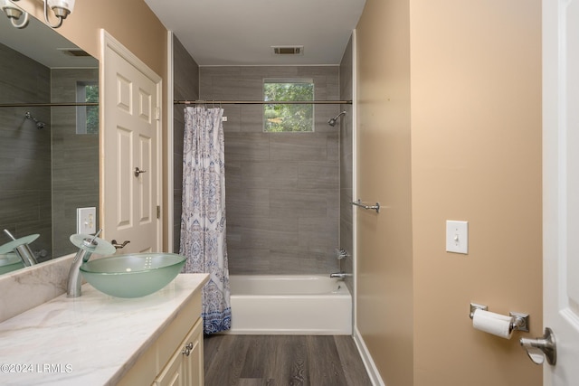 bathroom with wood-type flooring, vanity, and shower / bath combo