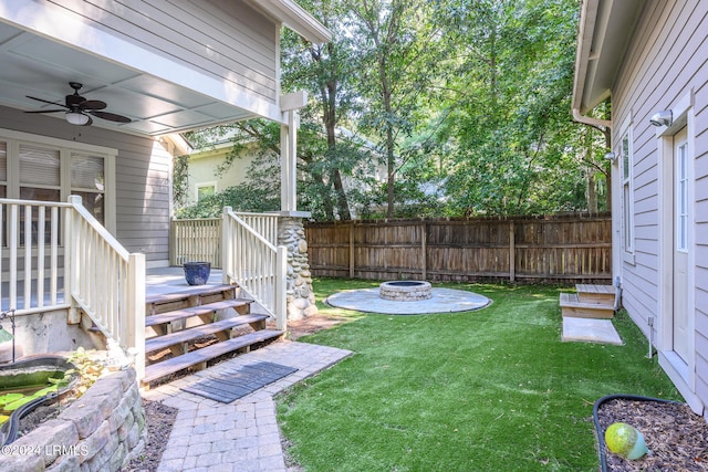 view of yard with a wooden deck, ceiling fan, and an outdoor fire pit