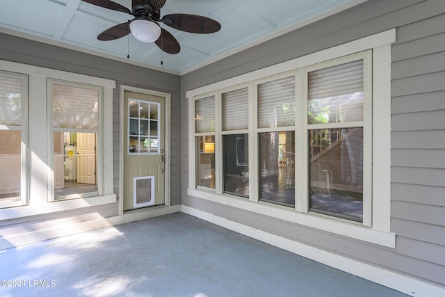 unfurnished sunroom with coffered ceiling and ceiling fan