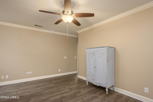 empty room featuring crown molding, dark wood-type flooring, and ceiling fan