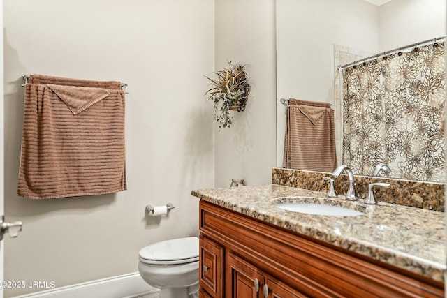 bathroom with walk in shower, vanity, and toilet