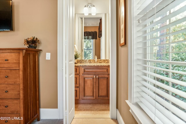 hall featuring a sink and baseboards