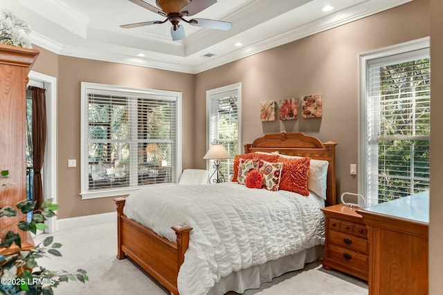 bedroom with ornamental molding, a tray ceiling, visible vents, and baseboards