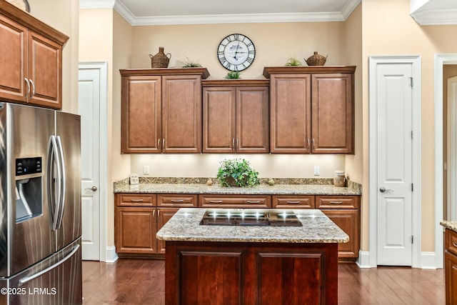 kitchen with light stone counters, a center island, and stainless steel refrigerator with ice dispenser