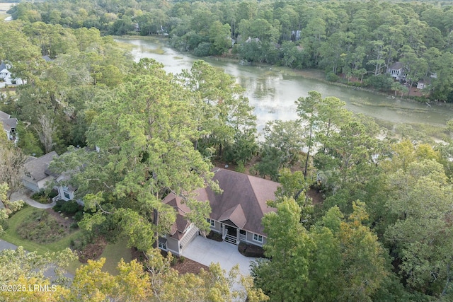 birds eye view of property featuring a forest view and a water view