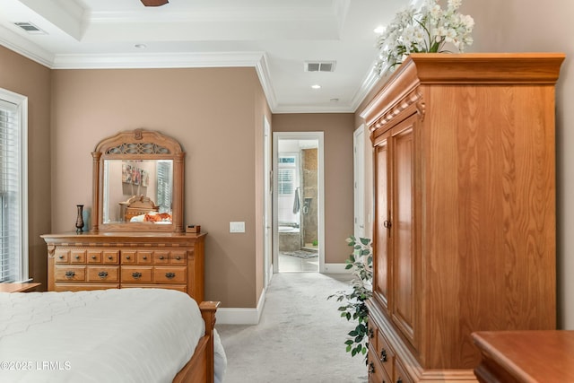 bedroom with a tray ceiling, crown molding, visible vents, light carpet, and baseboards