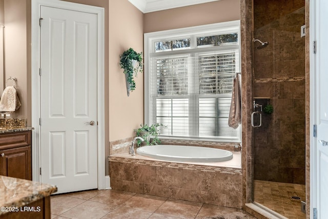 full bathroom featuring a stall shower, a garden tub, vanity, and tile patterned floors