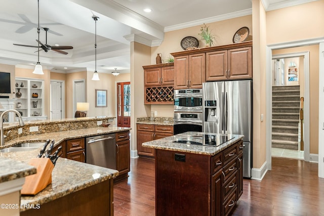 kitchen featuring appliances with stainless steel finishes, a kitchen island, a sink, and dark wood finished floors