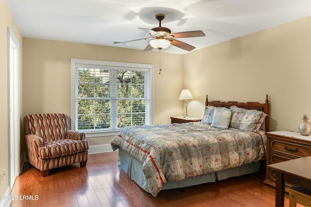 bedroom featuring a ceiling fan, baseboards, and wood finished floors