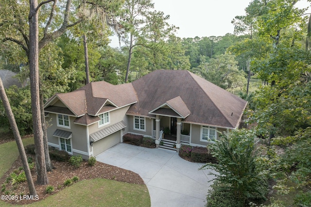 craftsman inspired home featuring driveway, roof with shingles, an attached garage, and stucco siding