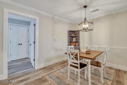 50 Pebble Beach Cv Unit F111, Bluffton, SC 29910 - dining space featuring wood finished floors, a chandelier, and crown molding