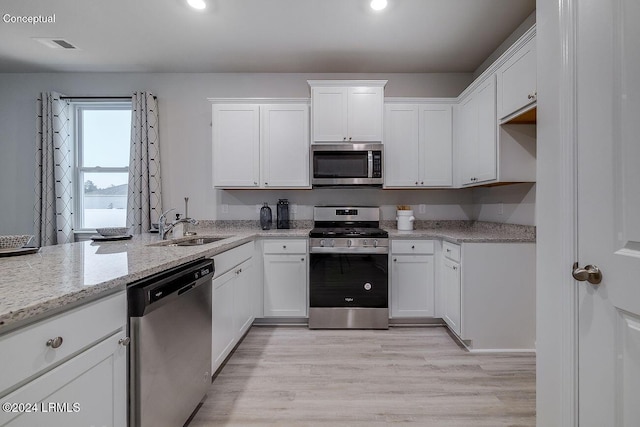 1549 Sanctum St, Ridgeland, SC 29936 - kitchen featuring appliances with stainless steel finishes, a sink, white cabinetry, light wood-type flooring, and recessed lighting