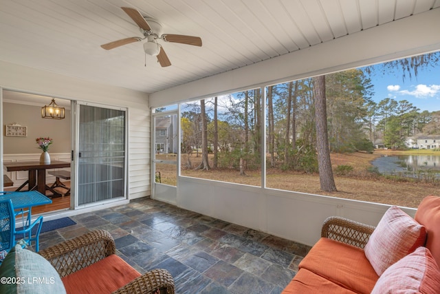 sunroom / solarium featuring ceiling fan and a water view