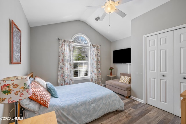 bedroom featuring wood finished floors, visible vents, a ceiling fan, vaulted ceiling, and a closet