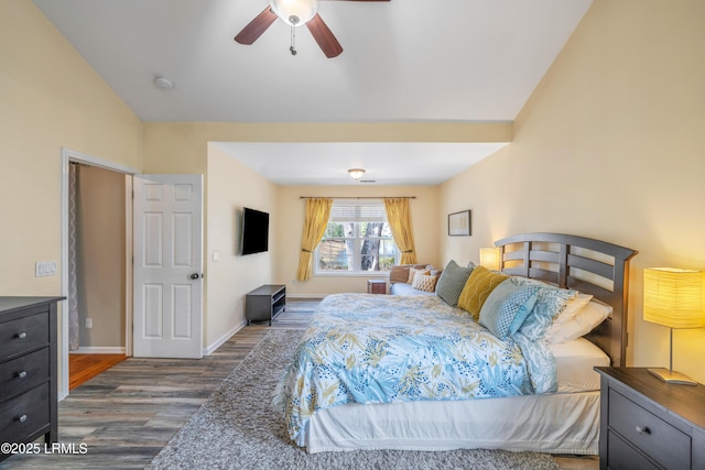 bedroom with lofted ceiling, dark wood-style flooring, a ceiling fan, and baseboards