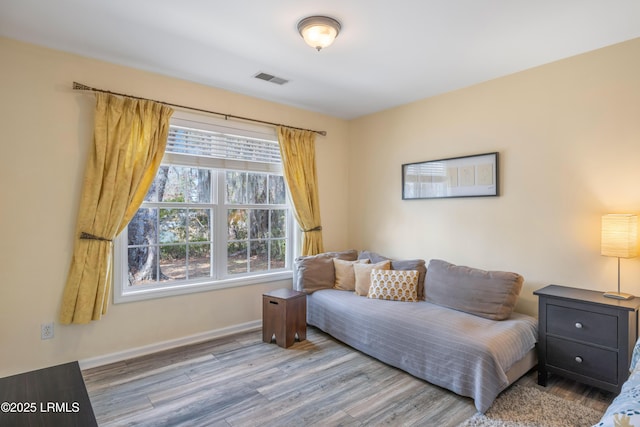 living area with visible vents, baseboards, and wood finished floors