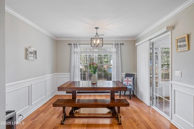 dining area with light wood-type flooring, a wealth of natural light, and a notable chandelier