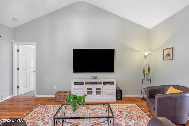 living room with lofted ceiling, baseboards, and wood finished floors