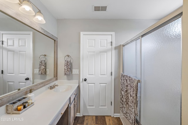 full bathroom featuring a stall shower, visible vents, wood finished floors, and vanity