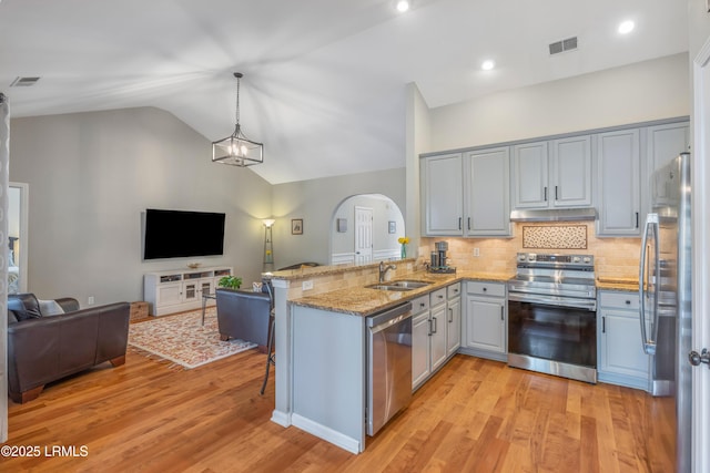 kitchen with under cabinet range hood, visible vents, appliances with stainless steel finishes, and open floor plan