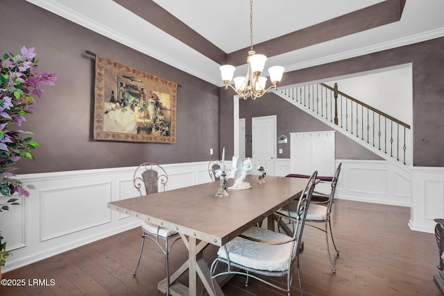 dining area featuring an inviting chandelier, a decorative wall, and dark wood-style floors
