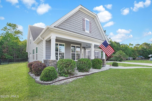 view of side of home featuring fence, a yard, and stone siding