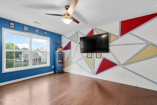 playroom with baseboards, visible vents, hardwood / wood-style flooring, and ceiling fan