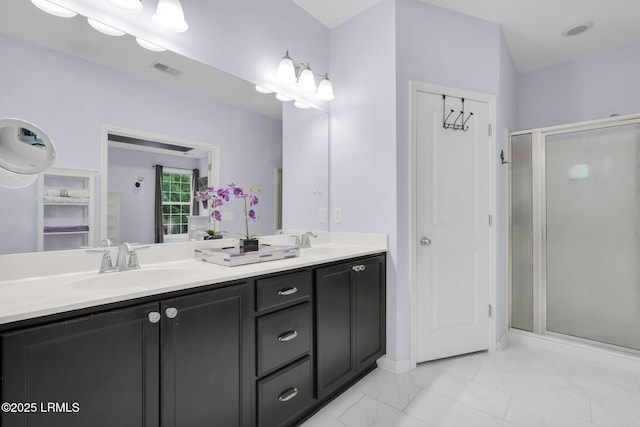 bathroom featuring double vanity, marble finish floor, a sink, visible vents, and a stall shower