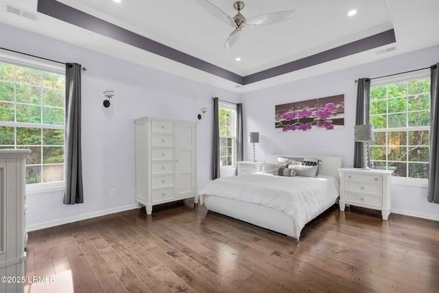 bedroom featuring hardwood / wood-style floors, visible vents, crown molding, and baseboards