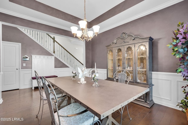 dining area with a wainscoted wall, a notable chandelier, dark wood-type flooring, and a decorative wall