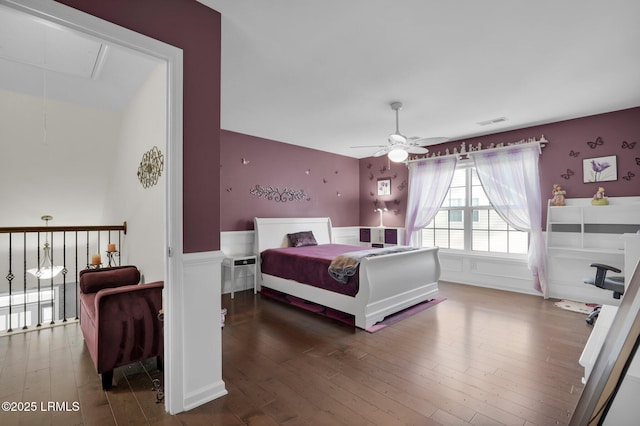 bedroom featuring attic access, a wainscoted wall, visible vents, and hardwood / wood-style flooring